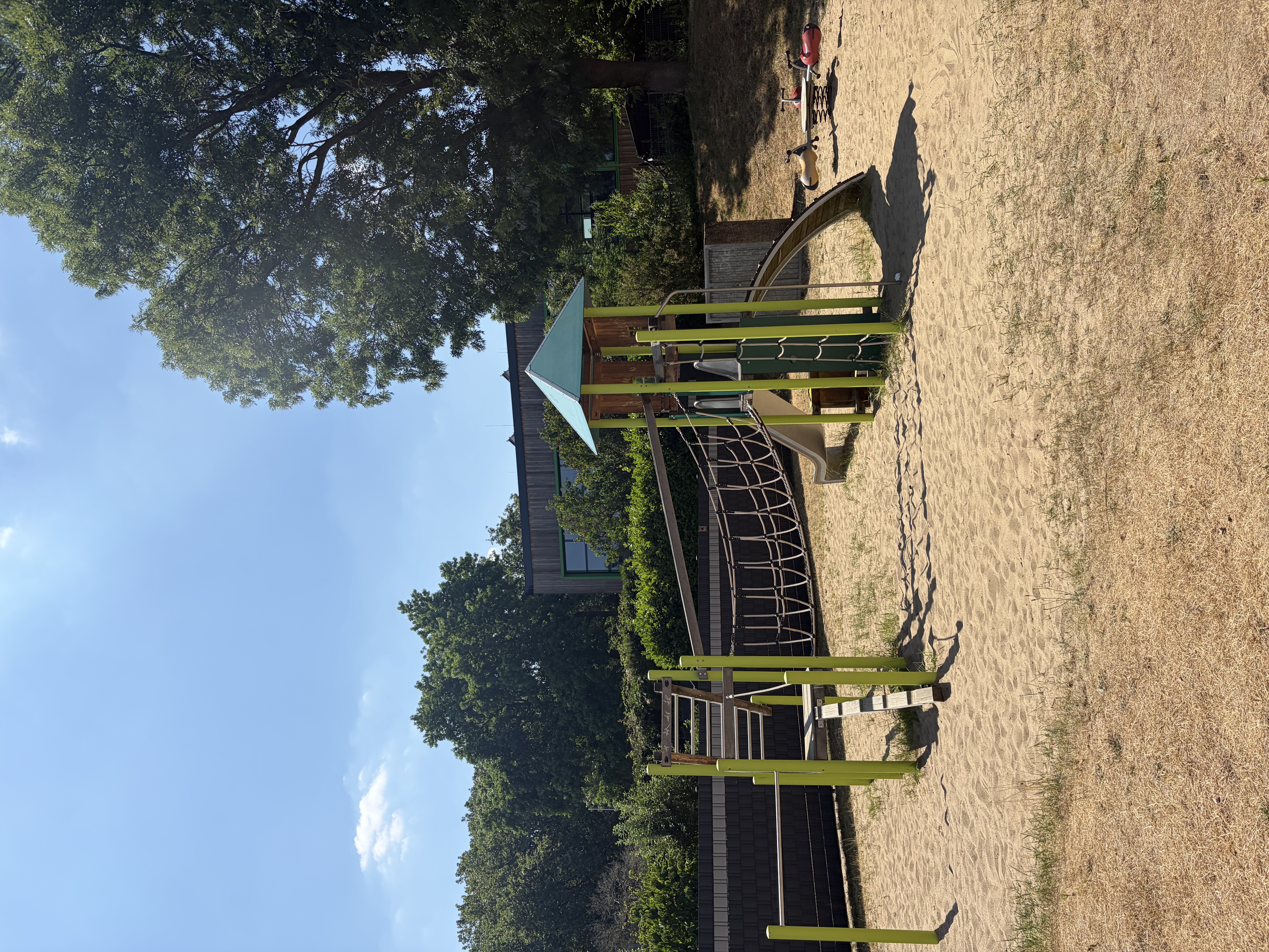 Spielplatz mit Klettergerüst und Rutsche in der Nähe